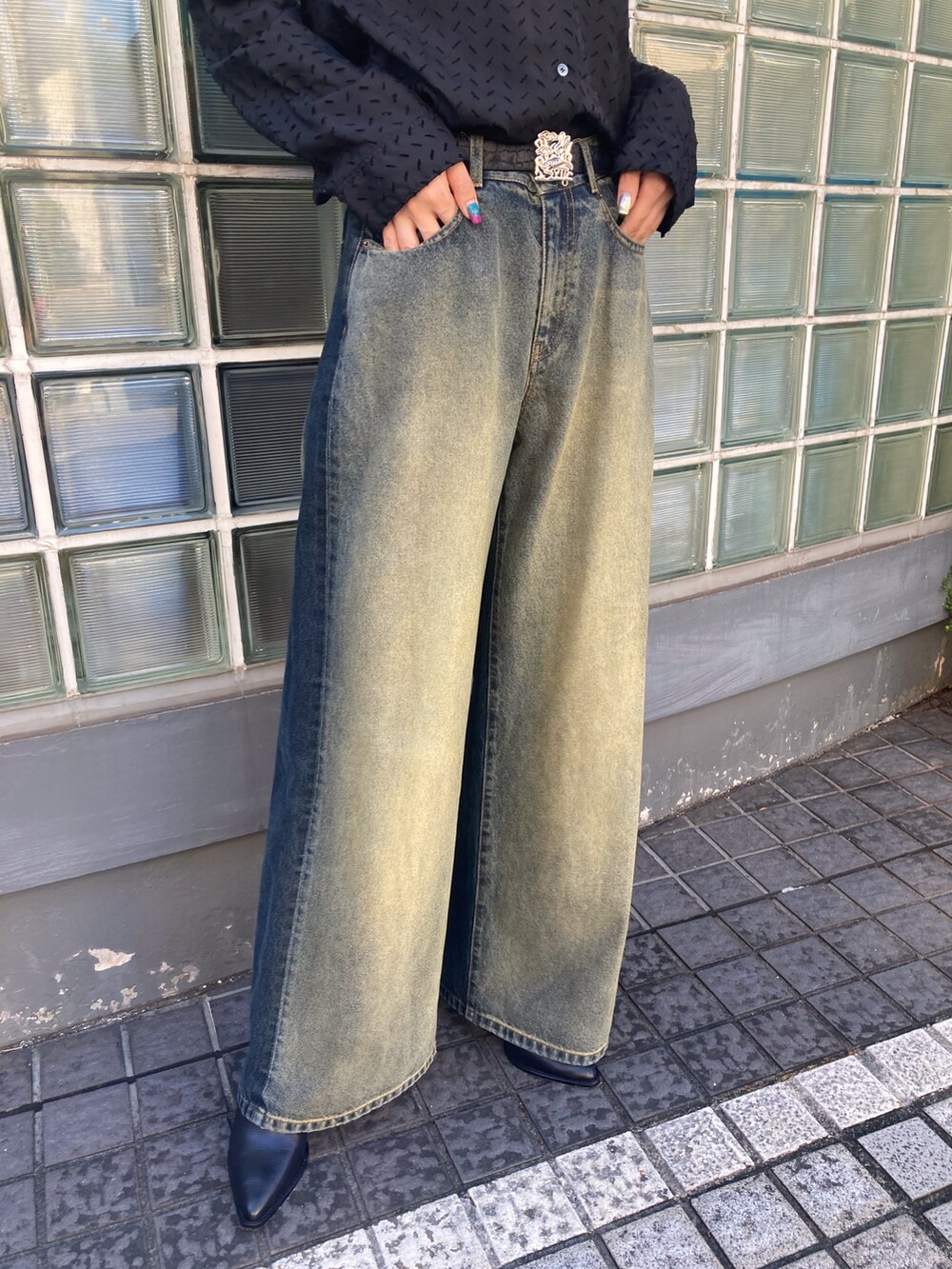 ブルー系のデニムパンツ、ブラック系のベルトを着用したレディースの秋コーディネートの4枚目の写真