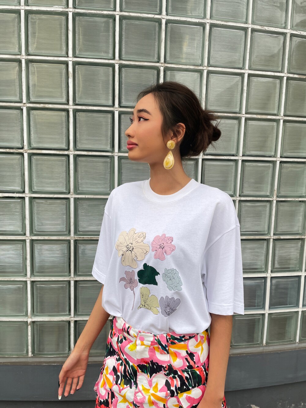 ホワイト系のトップス、ピンク系のスカート、ブラウン系のサンダルを着用したレディースの春コーディネートの3枚目の写真