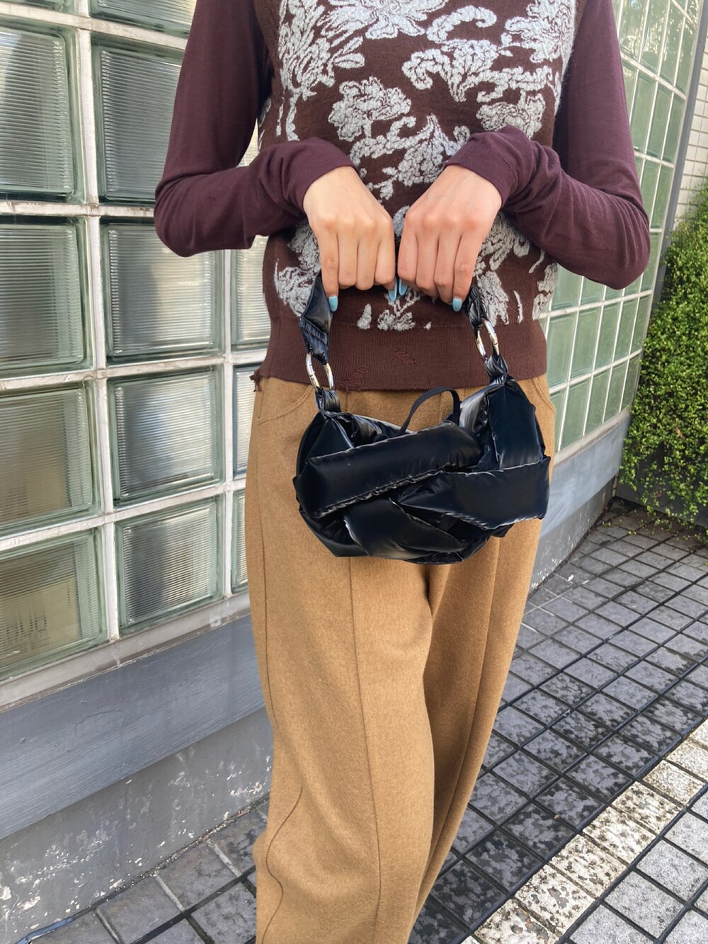 ブラウン系のベスト、ブラック系のその他パンツ、ブラック系のバッグを着用したレディースの秋コーディネートの2枚目の写真