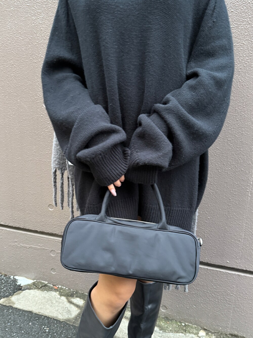 ブラック系のニット/セーター、ブラック系のショルダーバッグ、グレー系のストール/ショールを着用したレディースの冬コーディネートの4枚目の写真