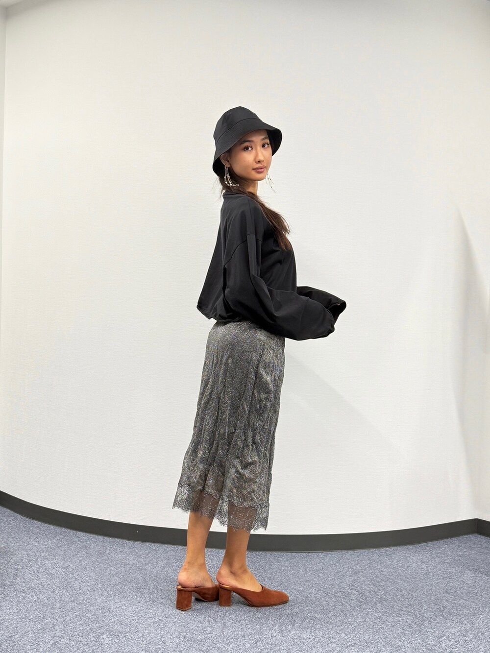 ブラック系のTシャツ/カットソー、グレー系のスカート、ブラウン系のシューズを着用したレディースの春コーディネートの2枚目の写真