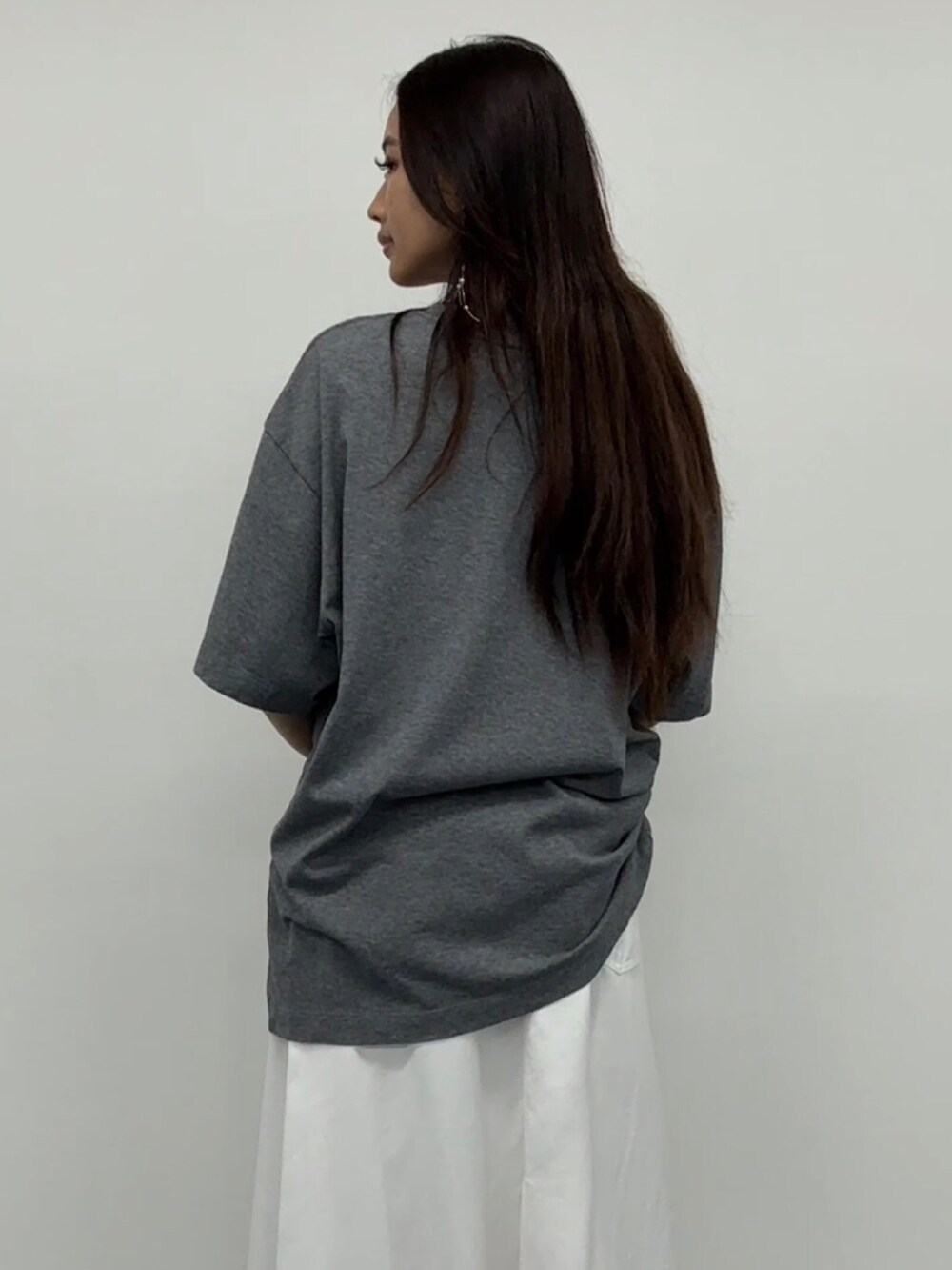 ホワイト系のデニムスカート、グレー系のトップスを着用したレディースの春コーディネートの3枚目の写真