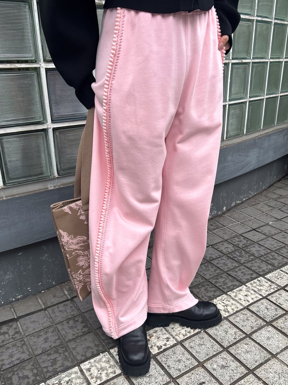 ブラック系のニット/セーター、ピンク系のその他パンツ、ベージュ系のトートバッグを着用したレディースの冬コーディネートの4枚目の写真