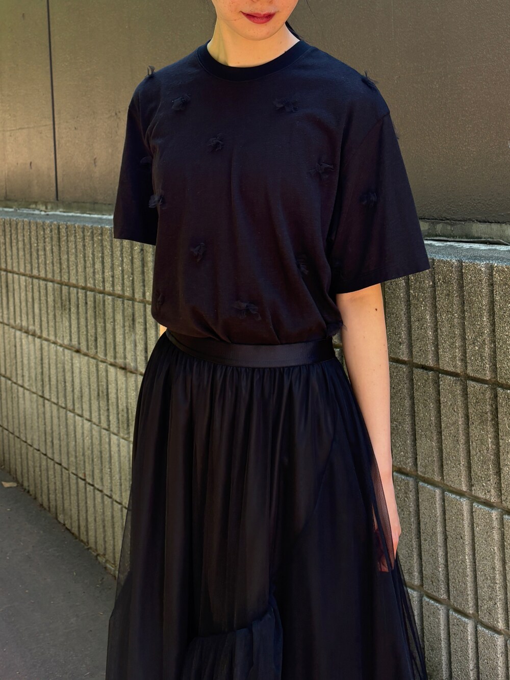 ブラック系のTシャツ/カットソー、ブラック系のスカート、ブラック系のショルダーバッグを着用したレディースの春コーディネートの2枚目の写真