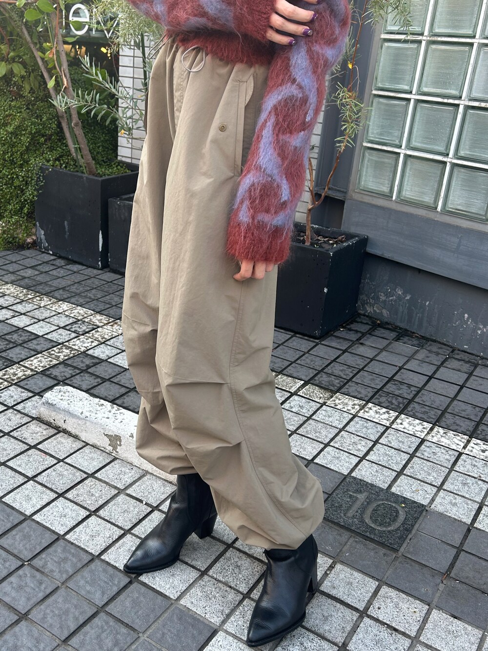 レッド系のカーディガン/ボレロ、ベージュ系のその他パンツを着用したレディースの秋コーディネートの4枚目の写真