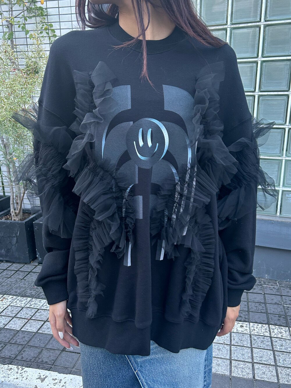 ブラック系のトップス、ブルー系のデニムスカートを着用したレディースの秋コーディネートの4枚目の写真