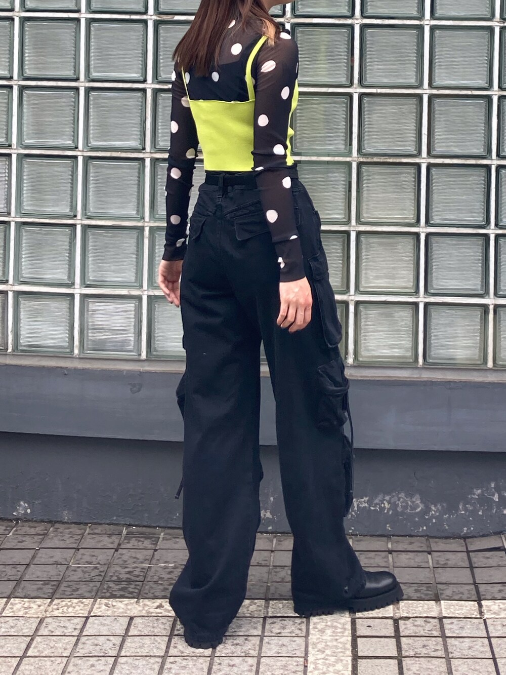 ブラック系のTシャツ/カットソー、グリーン系のニット/セーター、ブラック系のブーツを着用したレディースの夏コーディネートの5枚目の写真