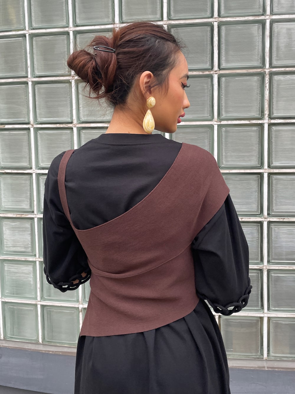 ブラウン系のニット/セーター、ブラック系のワンピース、ブラウン系のサンダルを着用したレディースの夏コーディネートの3枚目の写真