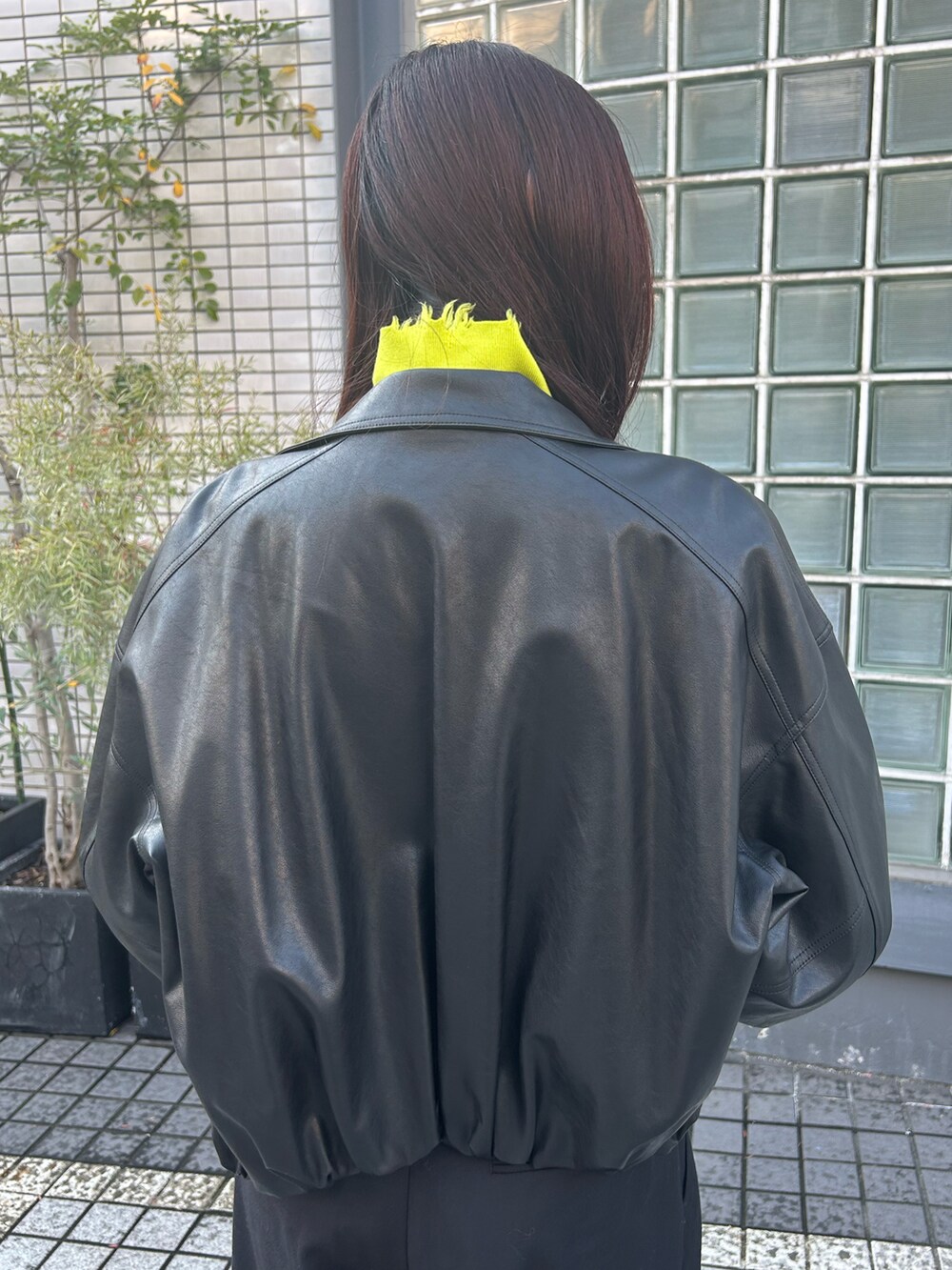ブラック系のカバーオール、イエロー系のニット/セーター、ブラック系のその他パンツを着用したレディースの秋コーディネートの4枚目の写真