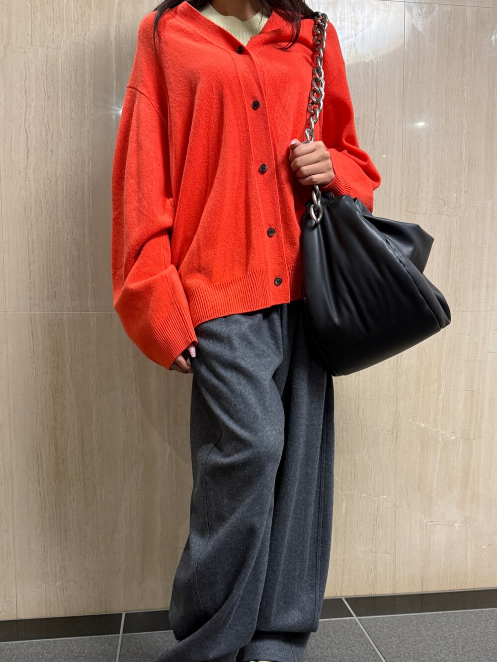 レッド系のトップス、グレー系のその他パンツ、ブラック系のショルダーバッグを着用したレディースの冬コーディネートの2枚目の写真