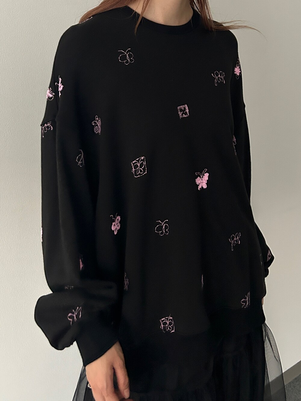 ブラック系のスウェット、ブラック系のスカートを着用したレディースの冬コーディネートの2枚目の写真