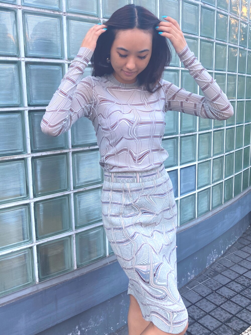 グレー系のTシャツ/カットソー、グレー系のスカート、ブラック系のブーティを着用したレディースの夏コーディネートの3枚目の写真