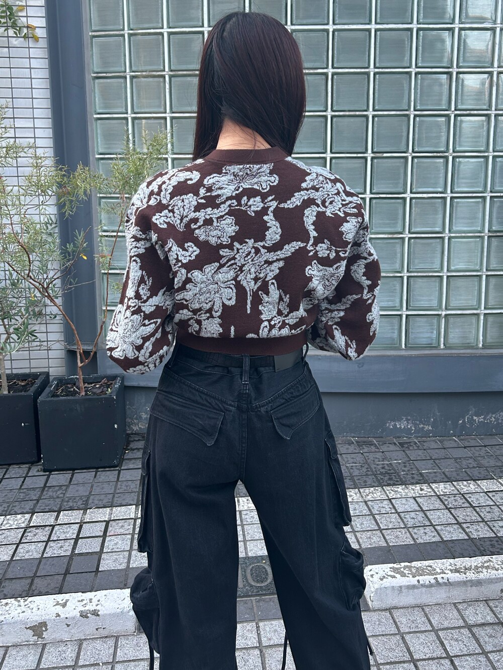 ブラウン系のニット/セーター、ブラック系のデニムパンツ、ブラック系のベルトを着用したレディースの秋コーディネートの2枚目の写真