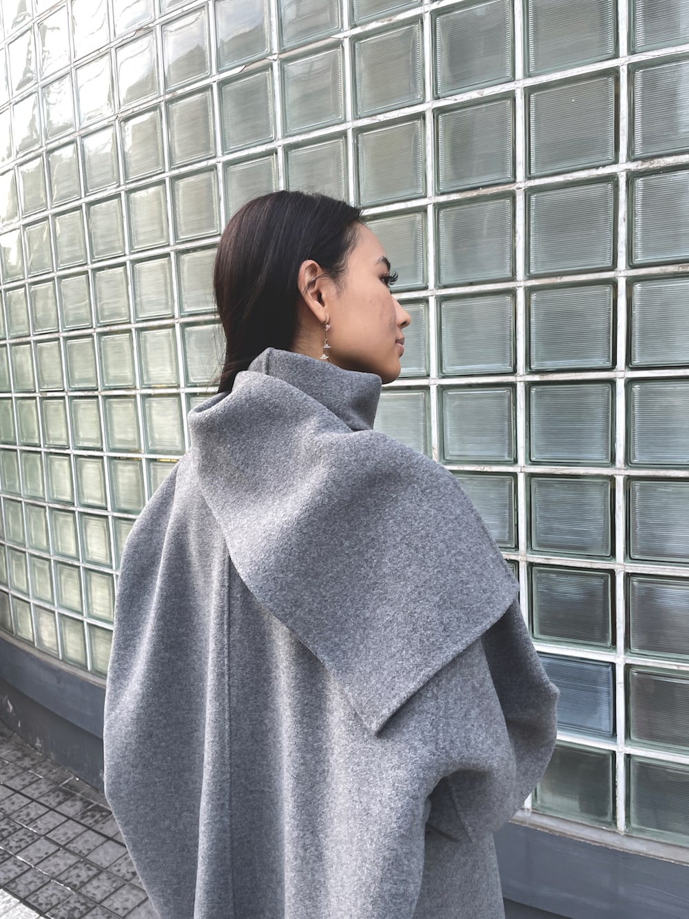 グレー系のその他アウター、ブラック系のスカート、ブラック系のブーツを着用したレディースの冬コーディネートの2枚目の写真