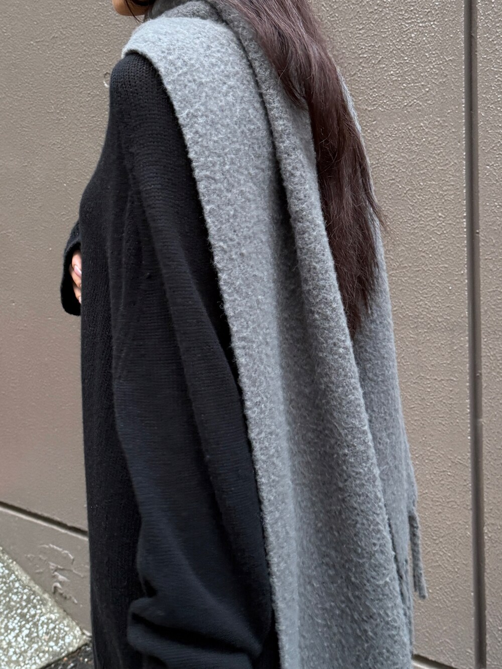 ブラック系のニット/セーター、ブラック系のショルダーバッグ、グレー系のストール/ショールを着用したレディースの冬コーディネートの3枚目の写真