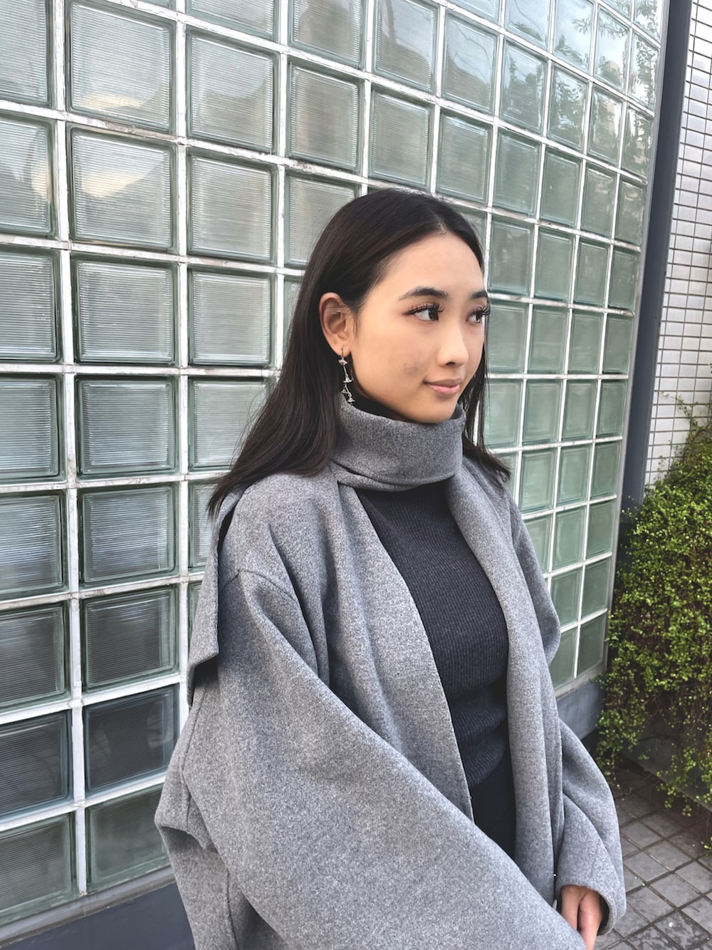 グレー系のその他アウター、ブラック系のスカート、ブラック系のブーツを着用したレディースの冬コーディネートの3枚目の写真