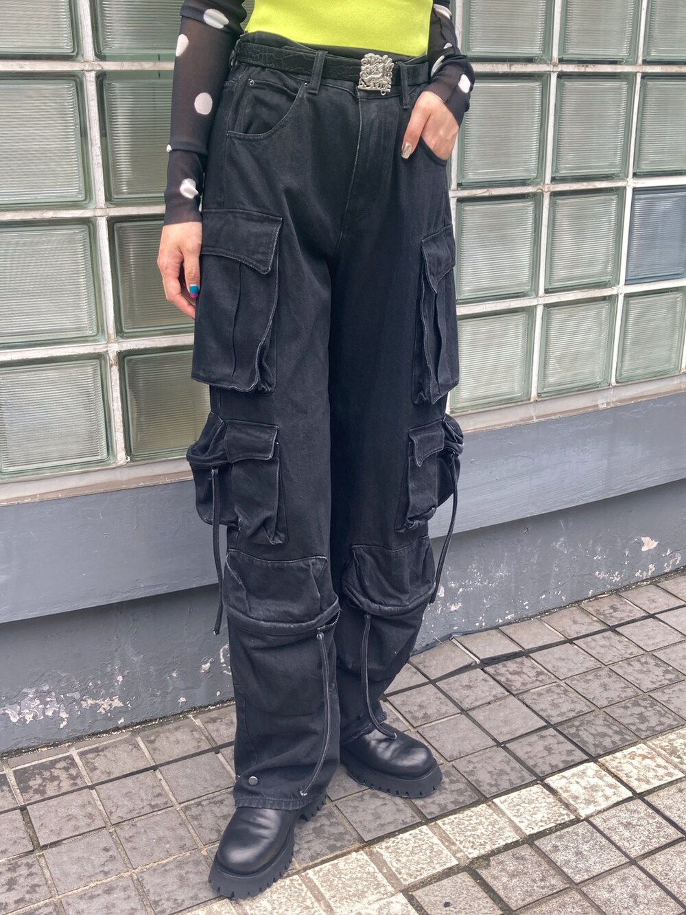 ブラック系のTシャツ/カットソー、グリーン系のニット/セーター、ブラック系のブーツを着用したレディースの夏コーディネートの3枚目の写真