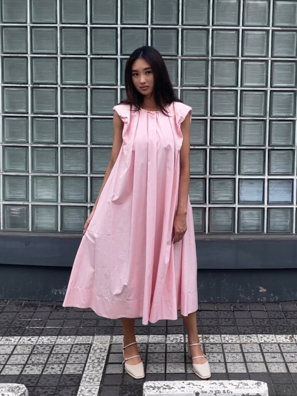 ピンク系のワンピースを着用したレディースの夏コーディネートの3枚目の写真