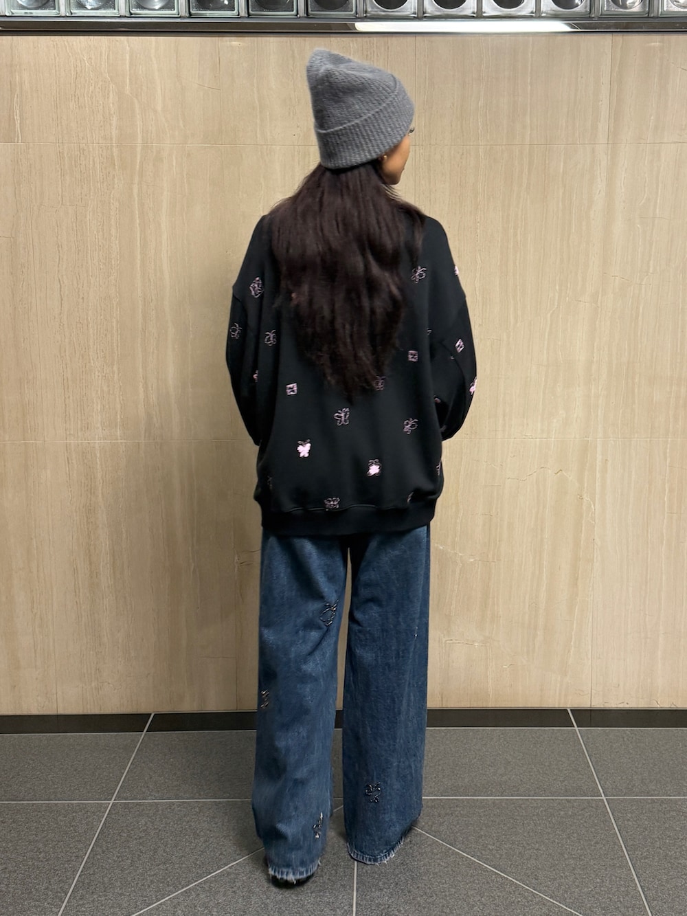 ブラック系のスウェット、ブルー系のデニムパンツ、グレー系のニットキャップ/ビーニーを着用したレディースの冬コーディネートの3枚目の写真