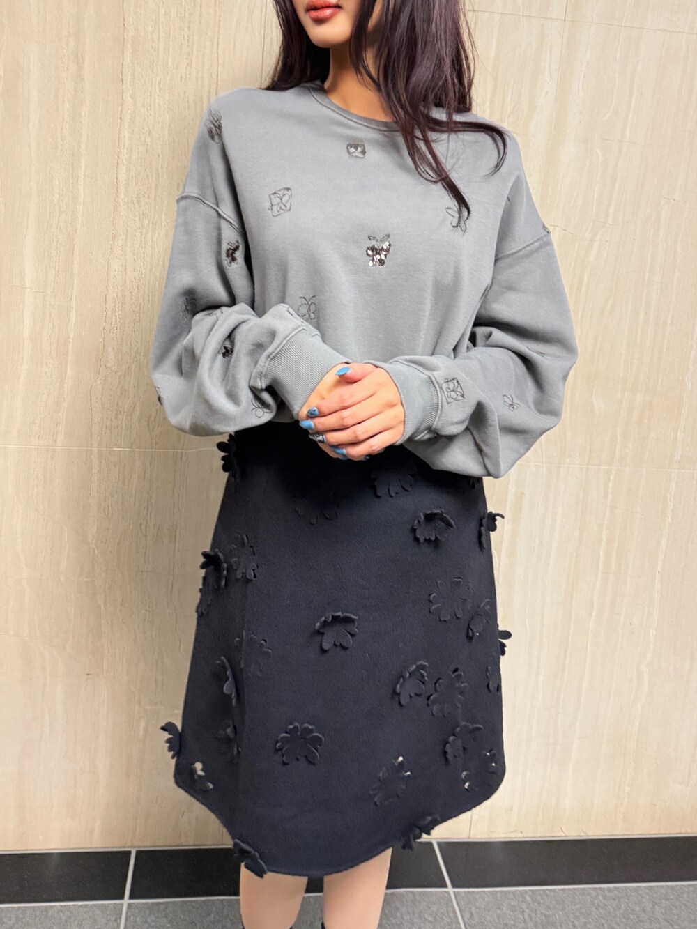 ブラック系のスカート、グレー系のトップスを着用したレディースの冬コーディネートの2枚目の写真