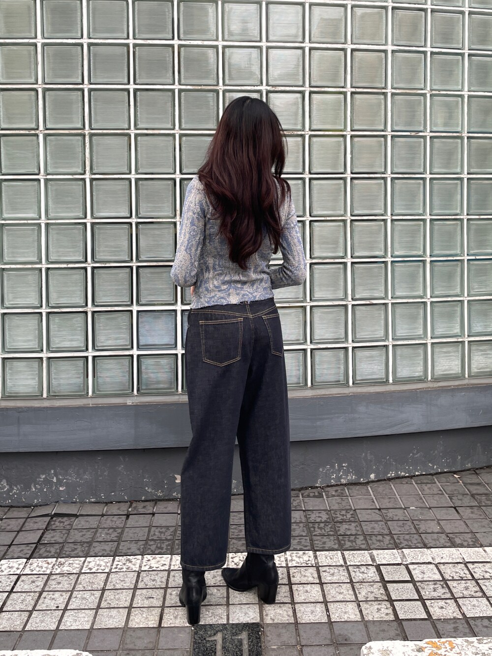 ブラック系のデニムパンツ、ブルー系のニット/セーターを着用したレディースの冬コーディネートの2枚目の写真