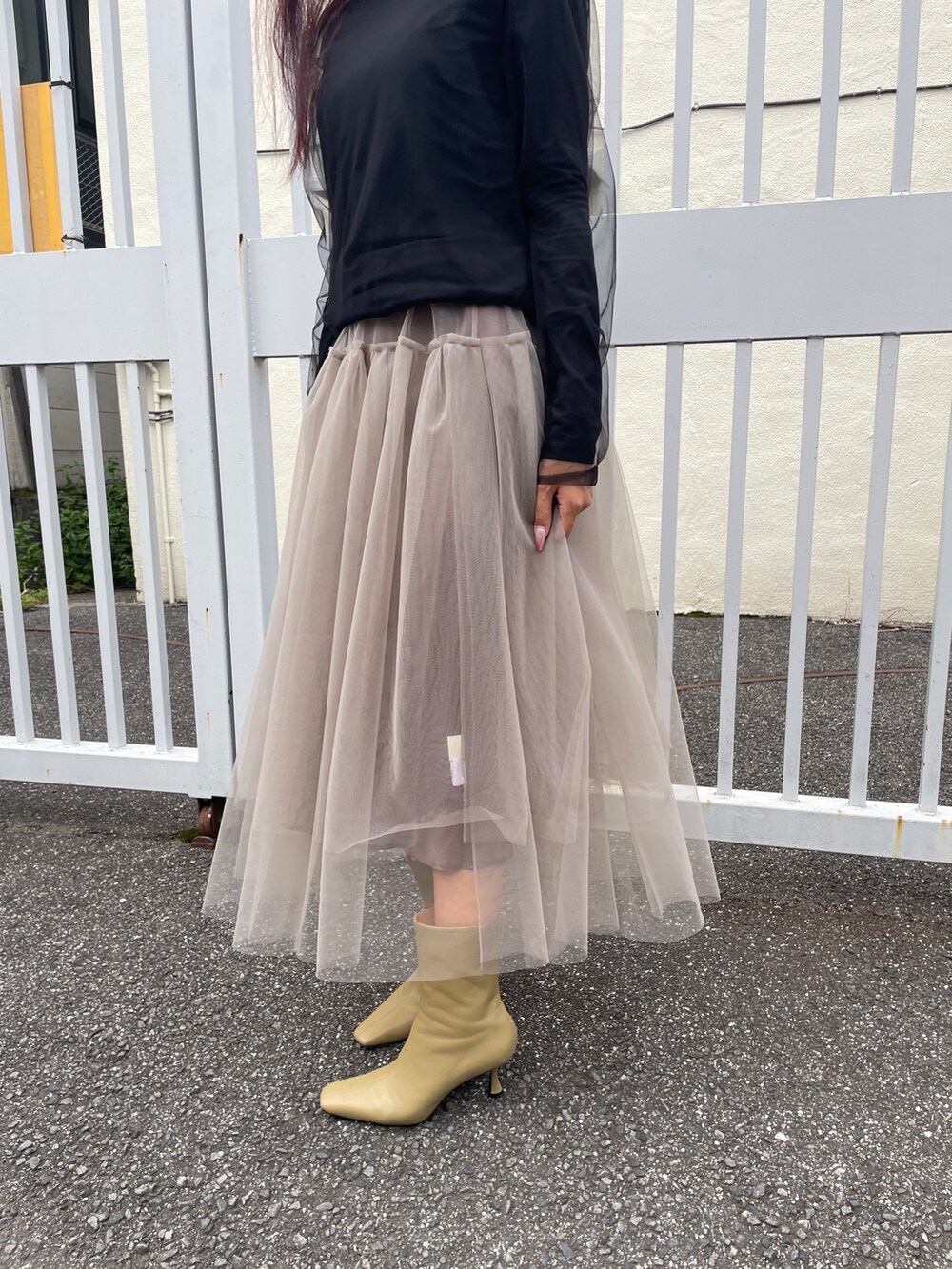 ベージュ系のスカート、ブラック系のTシャツ/カットソー、ベージュ系のシューズを着用したレディースの秋コーディネートの4枚目の写真