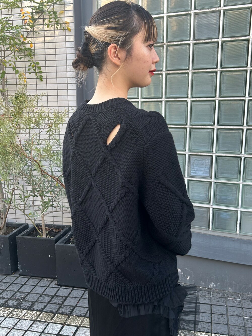 ブラック系のニット/セーター、ブラック系のスカート、ブラック系のハンドバッグを着用したレディースの秋コーディネートの4枚目の写真