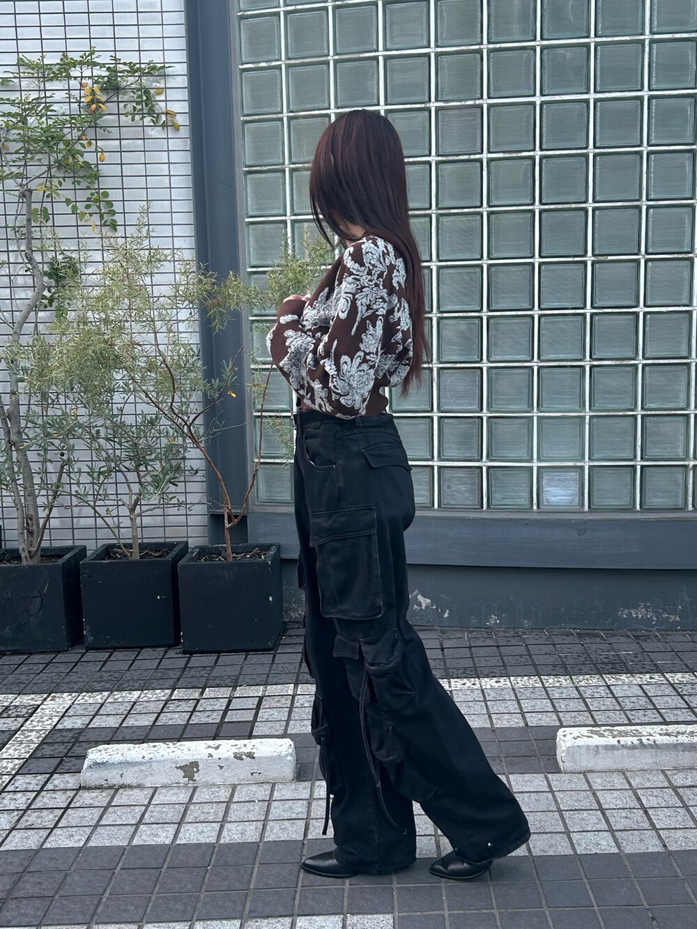 ブラウン系のニット/セーター、ブラック系のデニムパンツ、ブラック系のベルトを着用したレディースの秋コーディネートの4枚目の写真