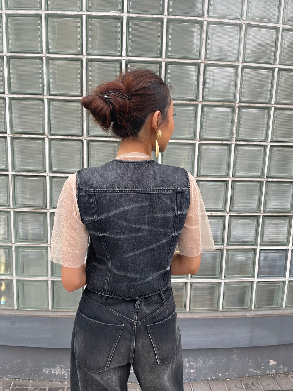 ブラック系のデニムパンツ、ベージュ系のTシャツ/カットソー、ブラック系のその他トップスを着用したレディースの夏コーディネートの3枚目の写真