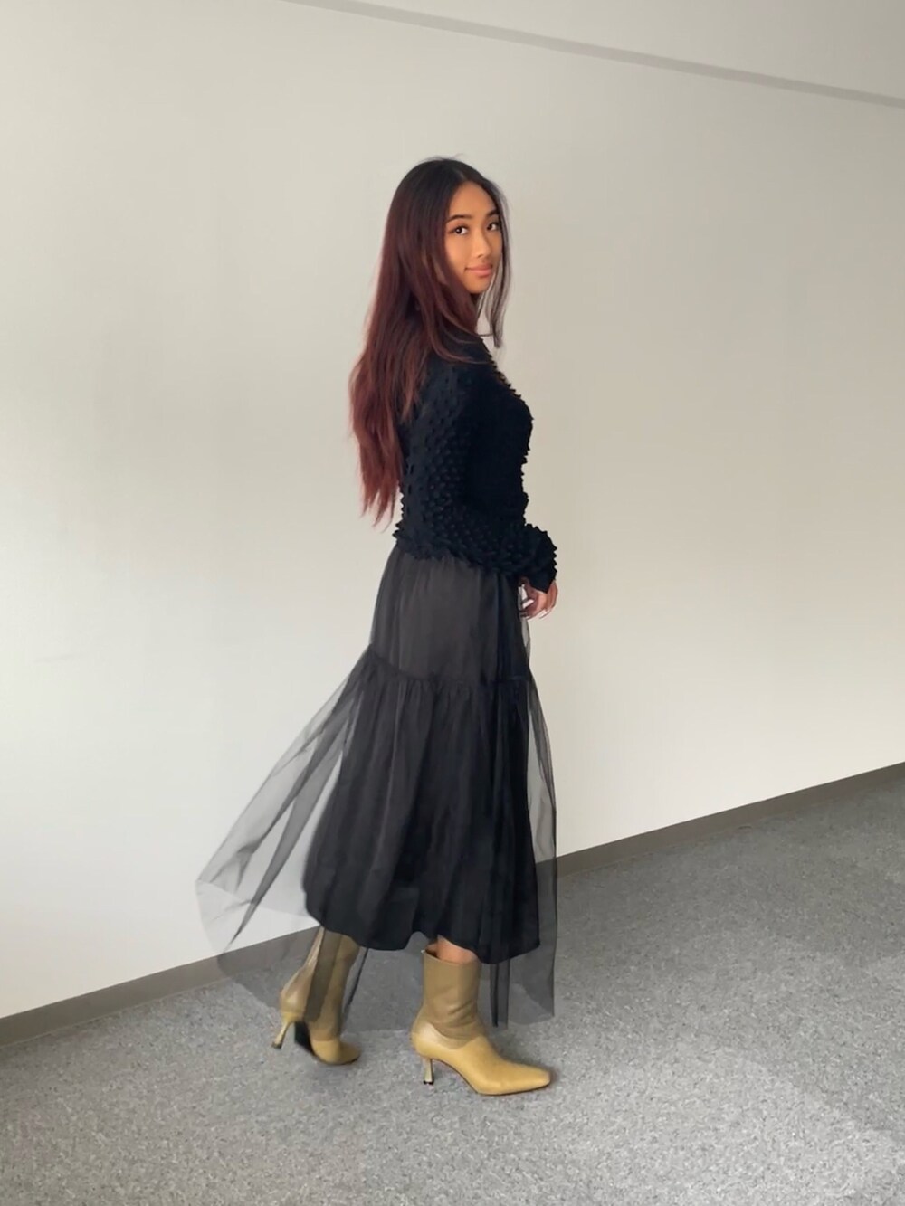 ブラック系のスカート、ブラック系のニット/セーター、ベージュ系のシューズを着用したレディースの秋コーディネートの3枚目の写真