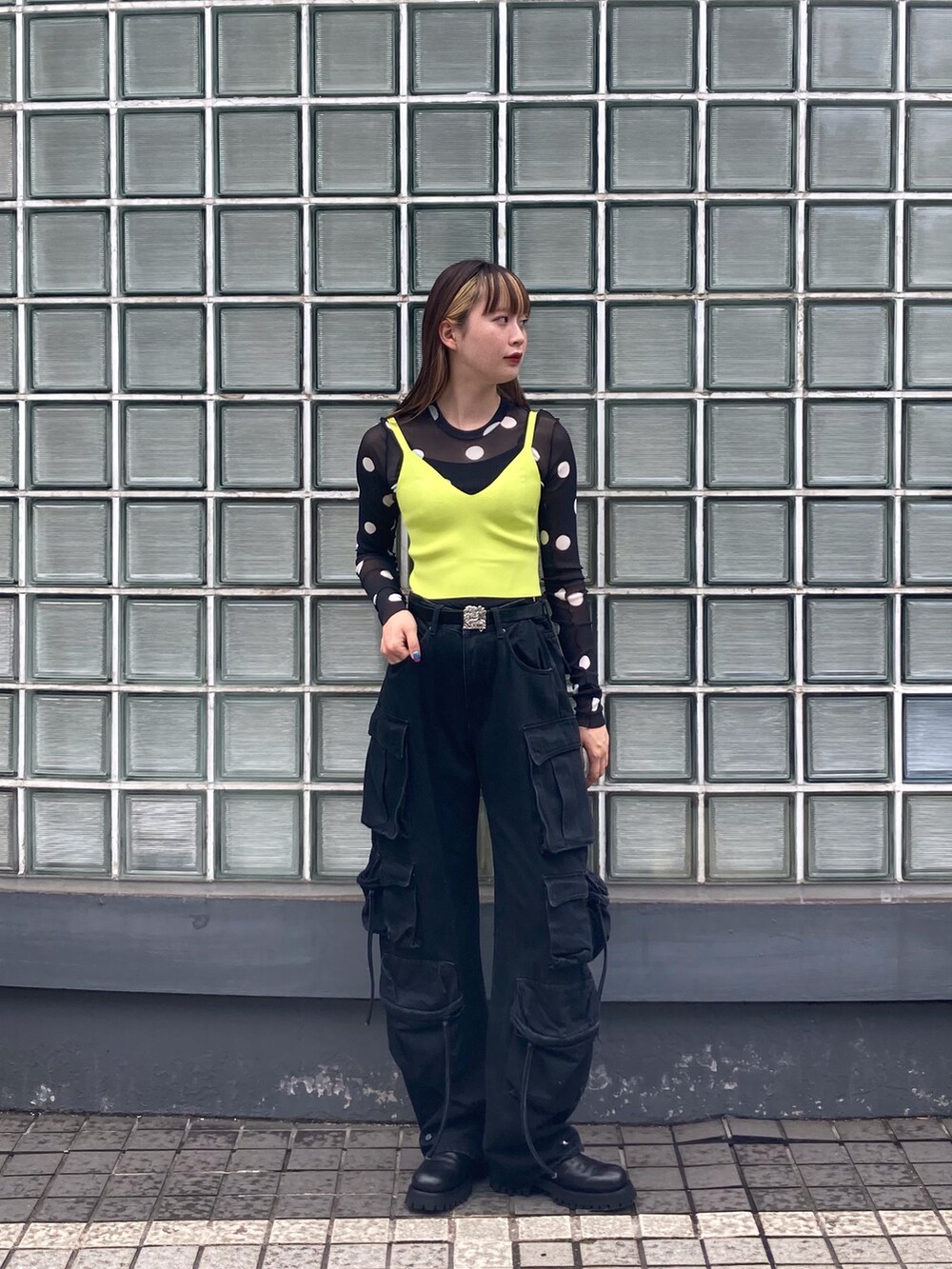 ブラック系のTシャツ/カットソー、グリーン系のニット/セーター、ブラック系のブーツを着用したレディースの夏コーディネートの2枚目の写真