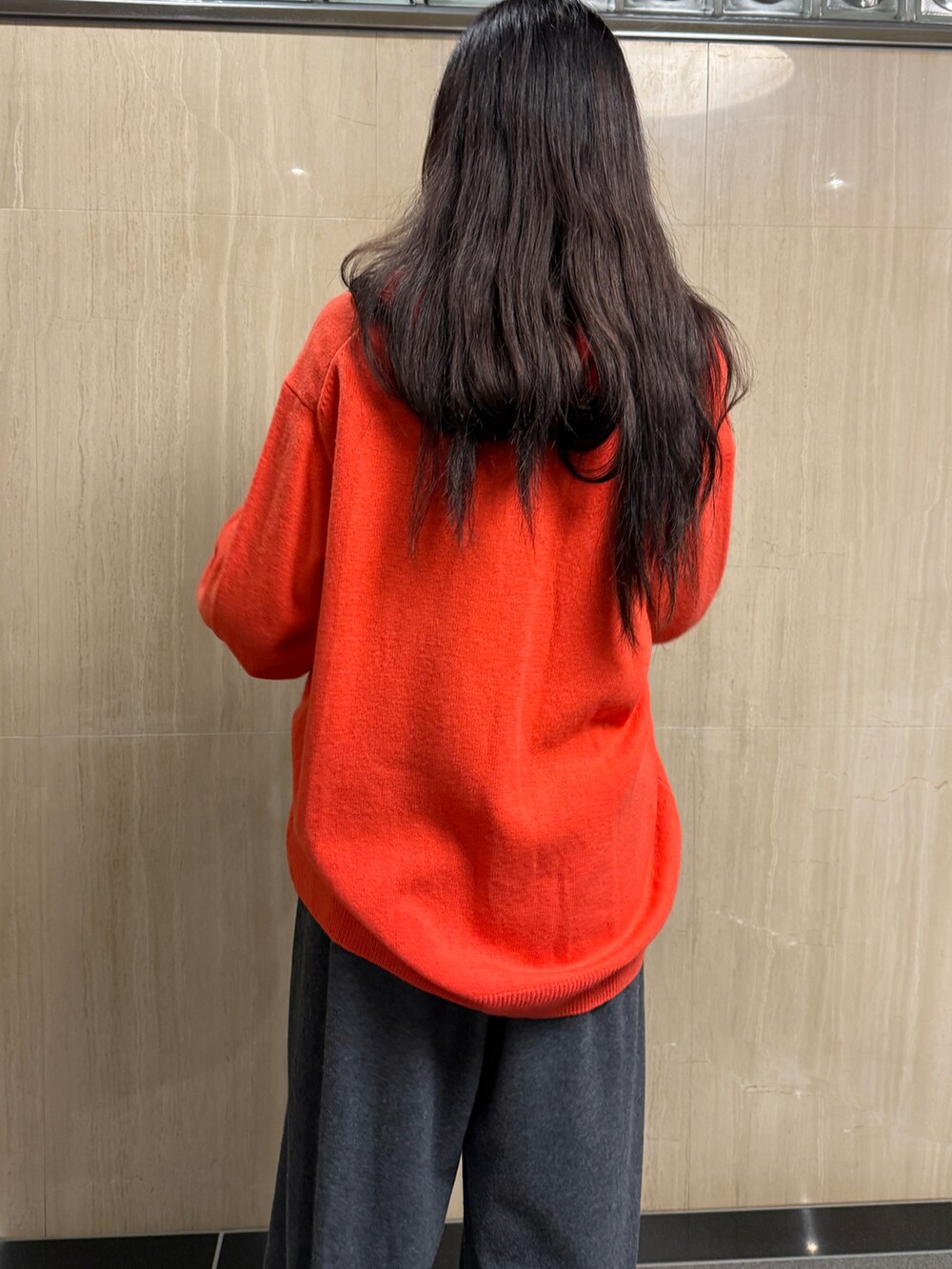 レッド系のトップス、グレー系のその他パンツ、ブラック系のショルダーバッグを着用したレディースの冬コーディネートの4枚目の写真