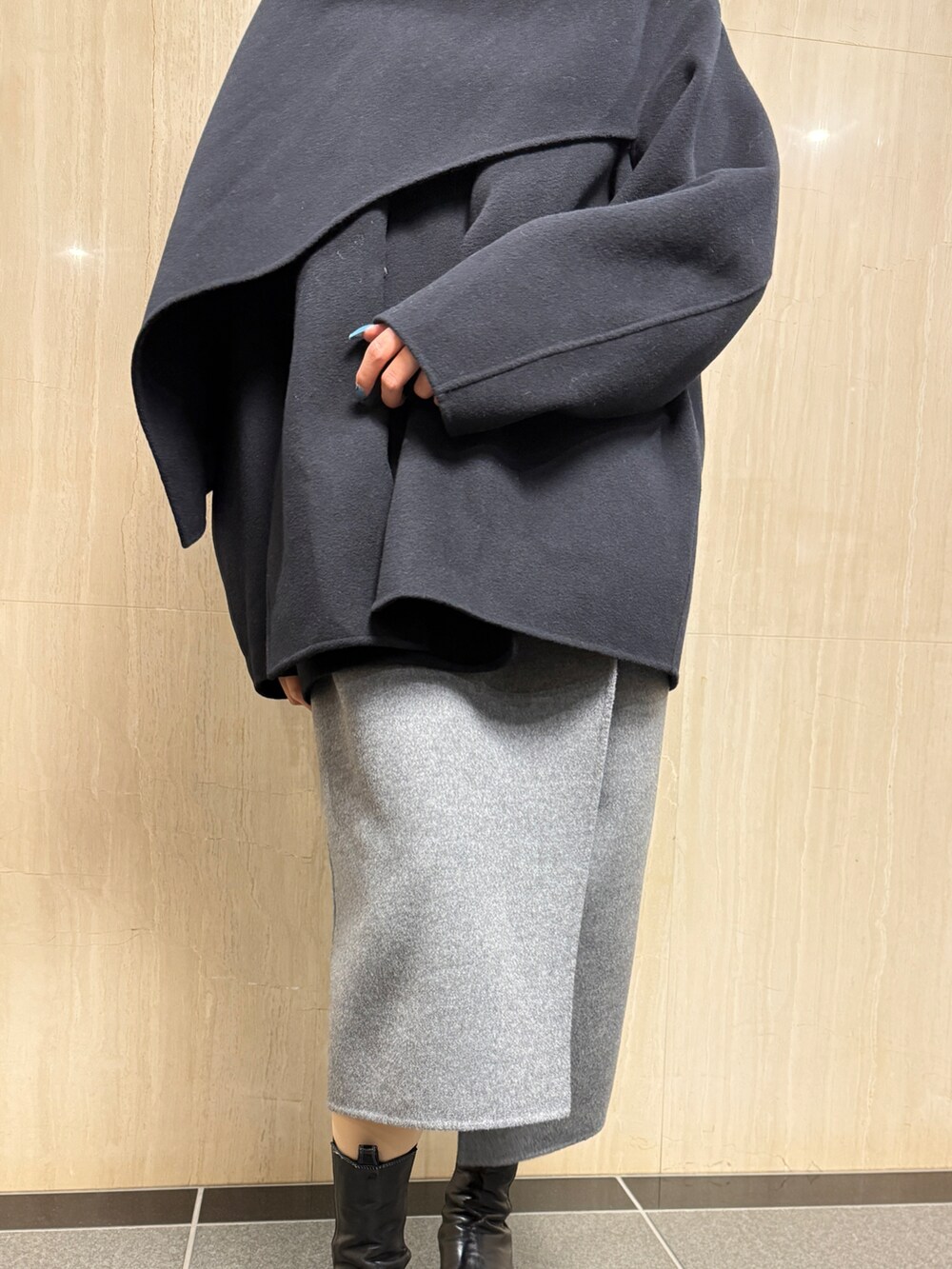 ブラック系のその他アウター、グレー系のスカートを着用したレディースの冬コーディネートの2枚目の写真