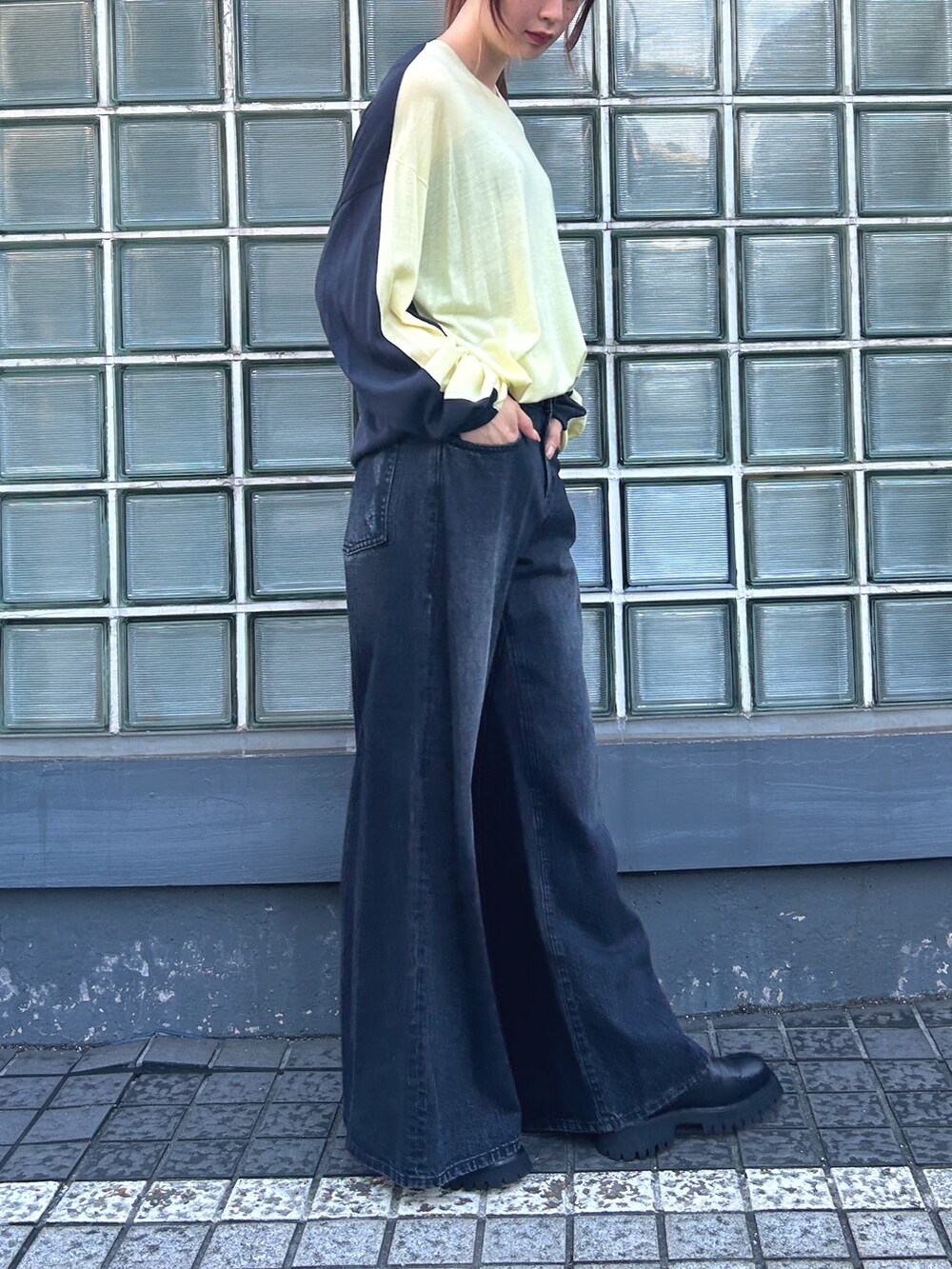 イエロー系のトップス、ブラック系のデニムパンツを着用したレディースの夏コーディネートの3枚目の写真