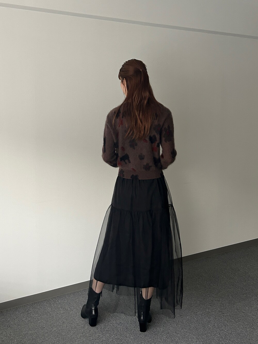 ブラウン系のカーディガン/ボレロ、ブラック系のスカートを着用したレディースの秋コーディネートの2枚目の写真