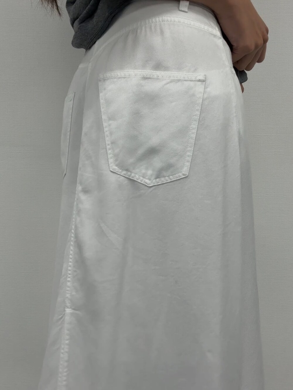 ホワイト系のデニムスカート、グレー系のトップスを着用したレディースの春コーディネートの4枚目の写真