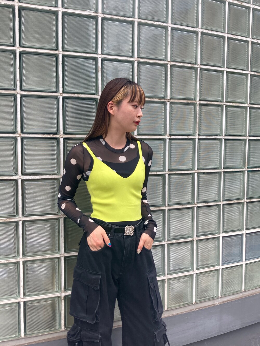 ブラック系のTシャツ/カットソー、グリーン系のニット/セーター、ブラック系のブーツを着用したレディースの夏コーディネートの4枚目の写真