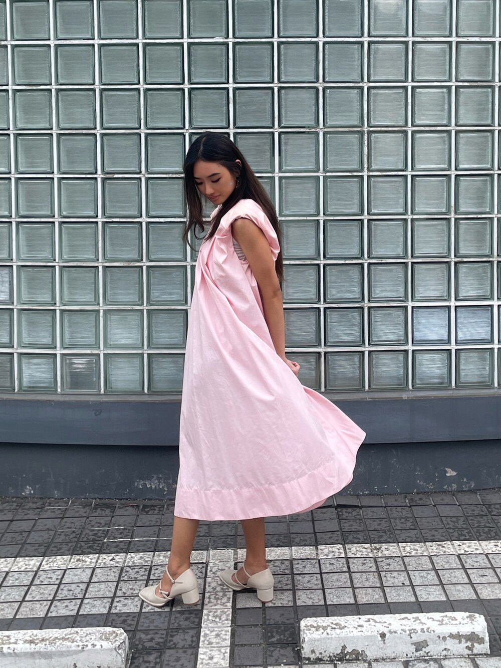 ピンク系のワンピースを着用したレディースの夏コーディネートの2枚目の写真