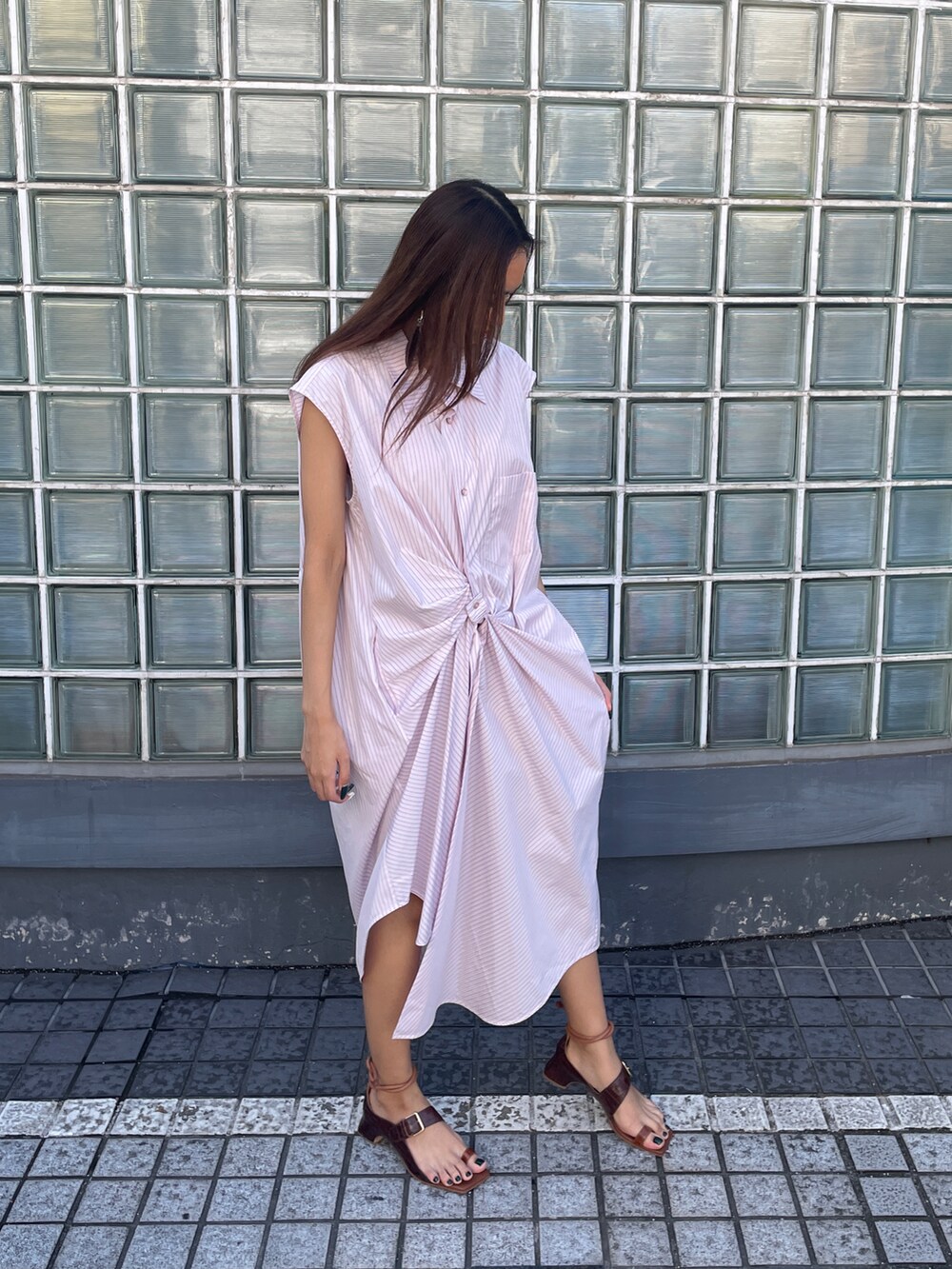 ピンク系のワンピース、ブラウン系のサンダルを着用したレディースの春コーディネートの3枚目の写真