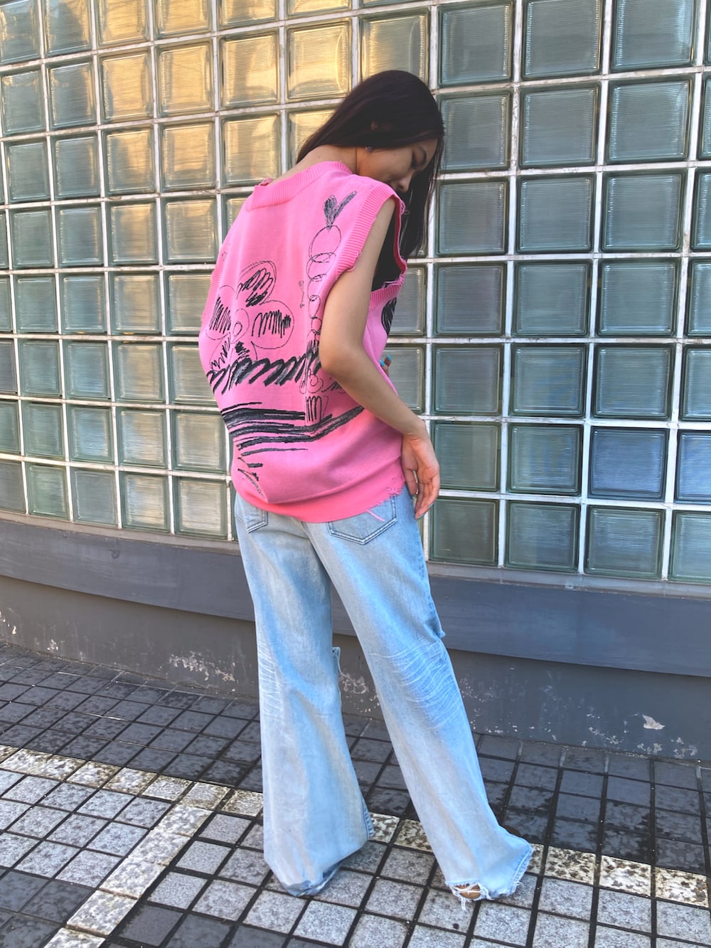ピンク系のベスト、ブルー系のデニムパンツを着用したレディースの夏コーディネートの2枚目の写真