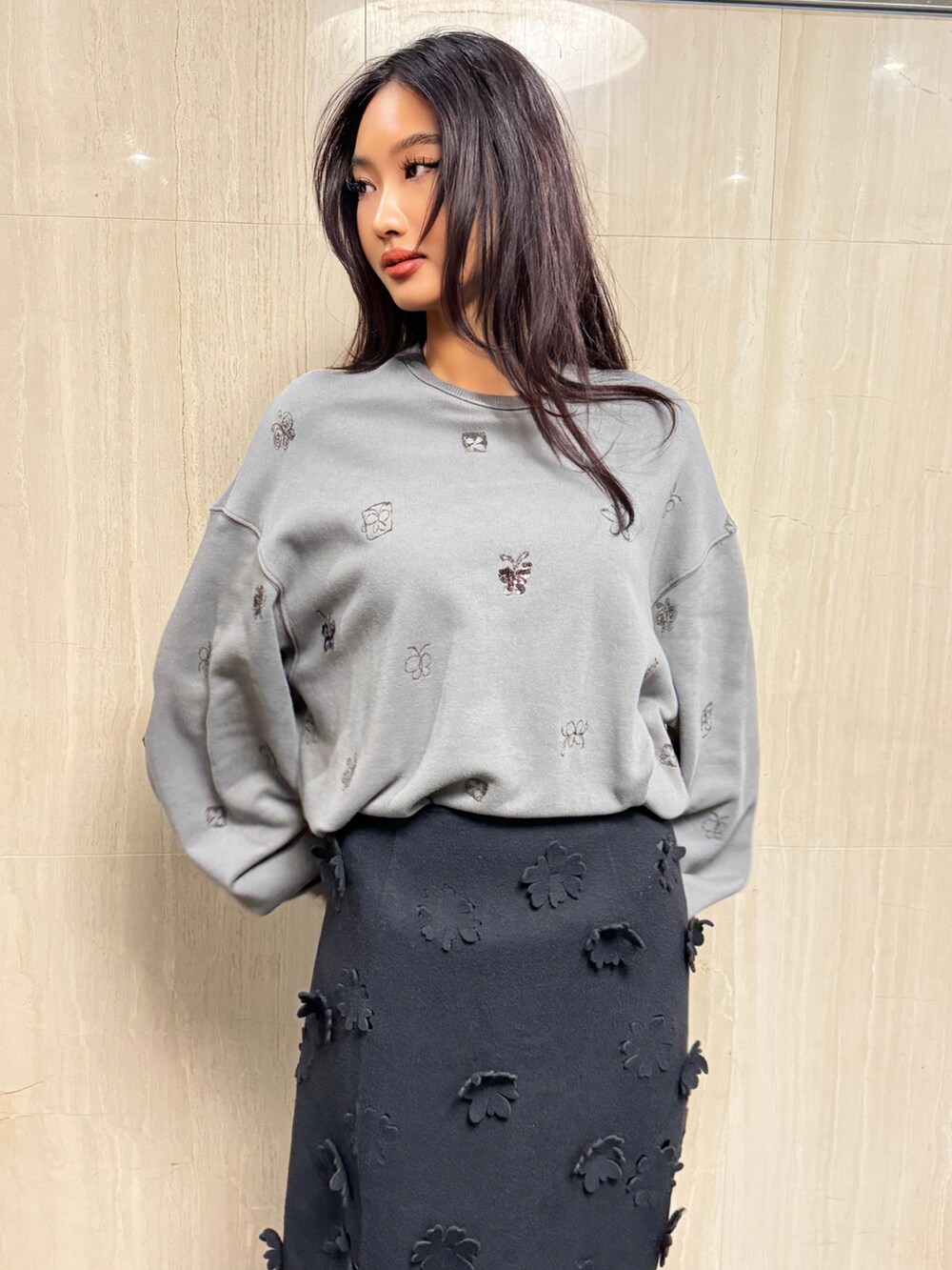 ブラック系のスカート、グレー系のトップスを着用したレディースの冬コーディネートの3枚目の写真