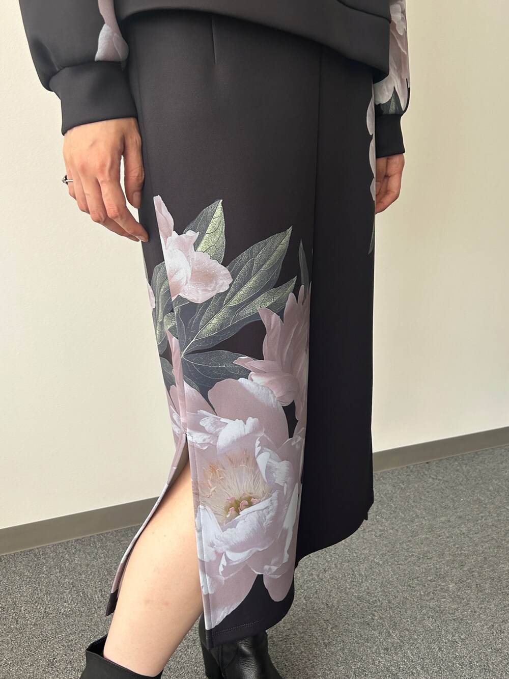 ブラック系のトップス、ブラック系のスカートを着用したレディースの秋コーディネートの3枚目の写真