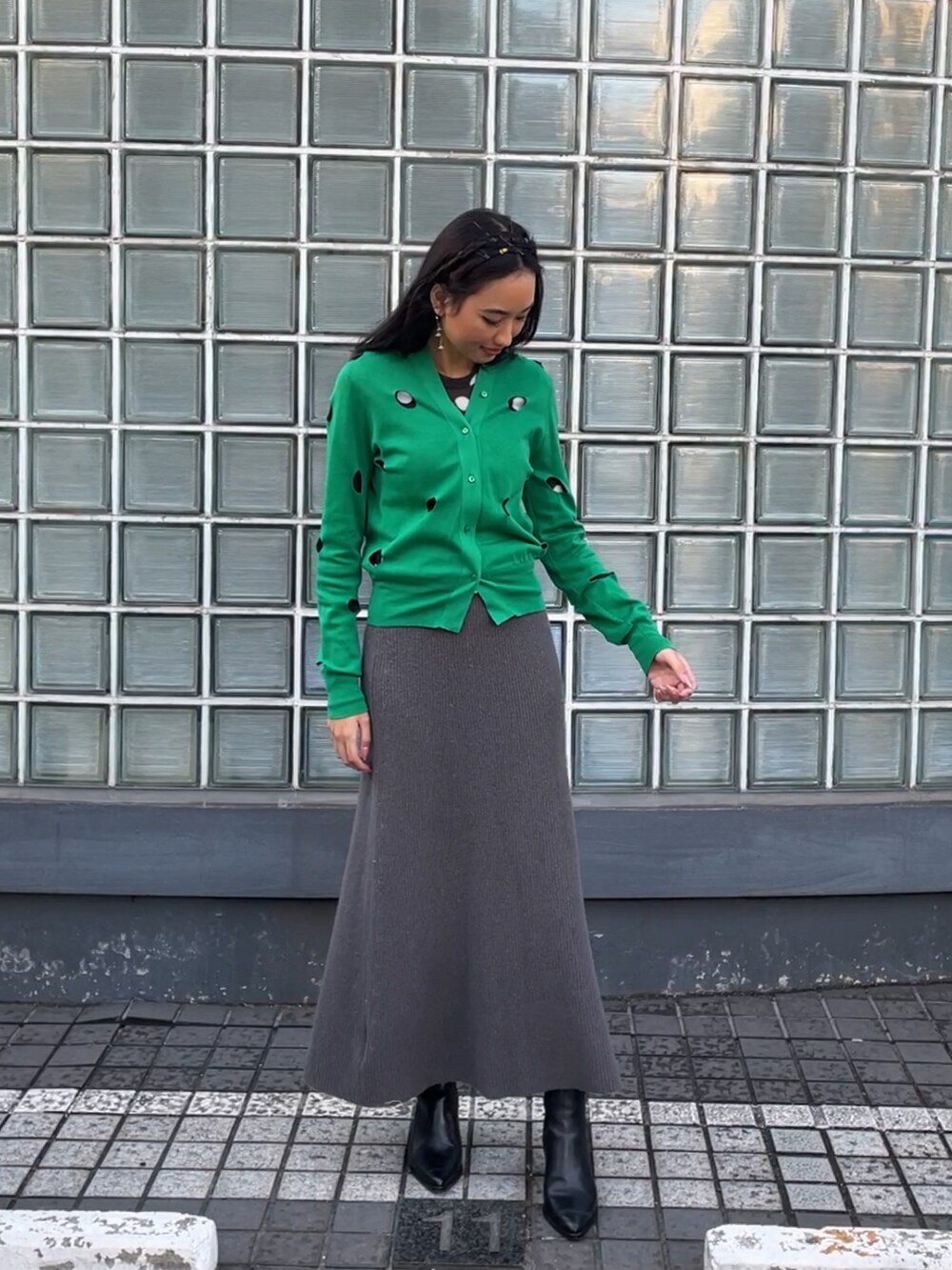 グリーン系のカーディガン/ボレロ、ブラック系のTシャツ/カットソー、グレー系のスカートを着用したレディースの冬コーディネートの3枚目の写真