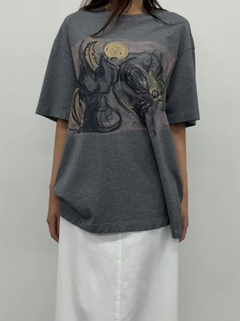 ホワイト系のデニムスカート、グレー系のトップスを着用したレディースの春コーディネートの2枚目の写真