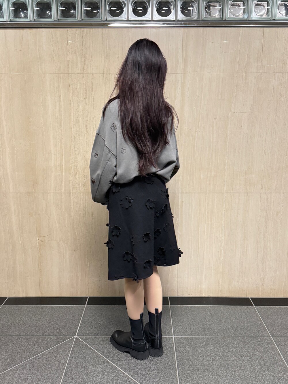 ブラック系のスカート、グレー系のトップスを着用したレディースの冬コーディネートの4枚目の写真