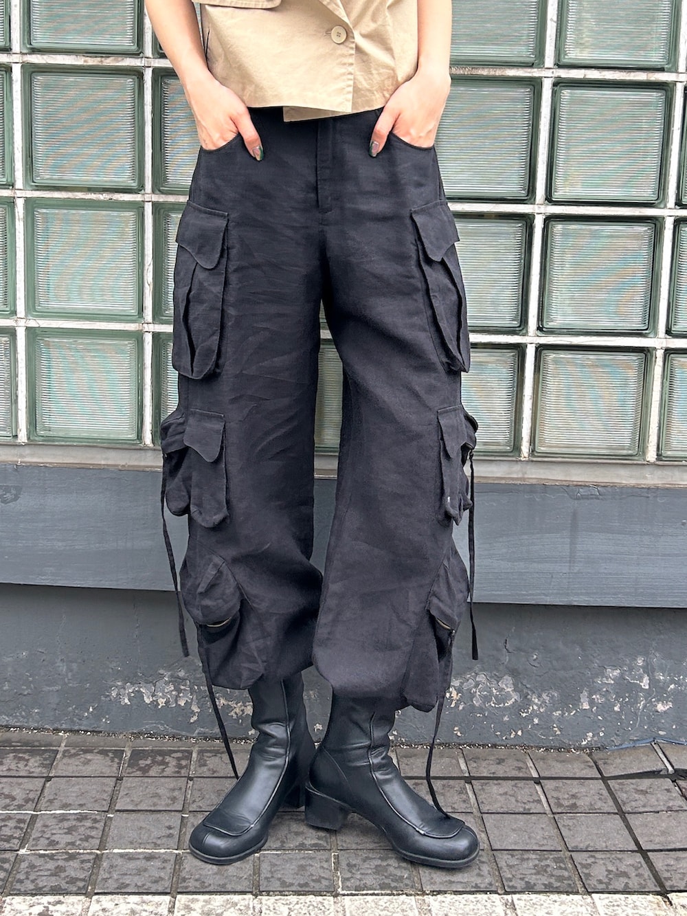 ベージュ系のベスト、ブラック系のデニムパンツを着用したレディースの夏コーディネートの3枚目の写真