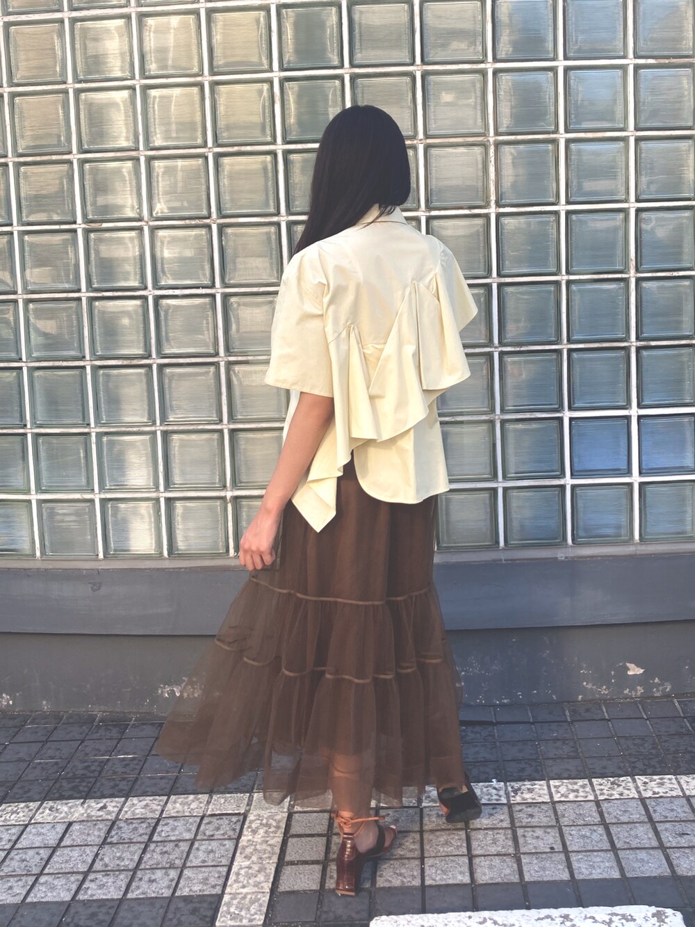 イエロー系のシャツ/ブラウス、ブラウン系のスカートを着用したレディースの夏コーディネートの2枚目の写真