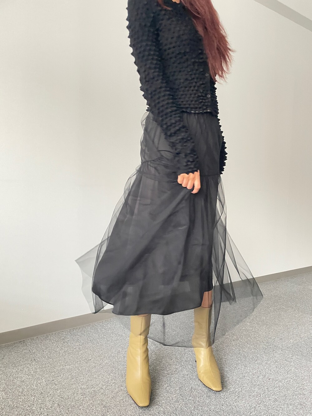 ブラック系のスカート、ブラック系のニット/セーター、ベージュ系のシューズを着用したレディースの秋コーディネートの4枚目の写真