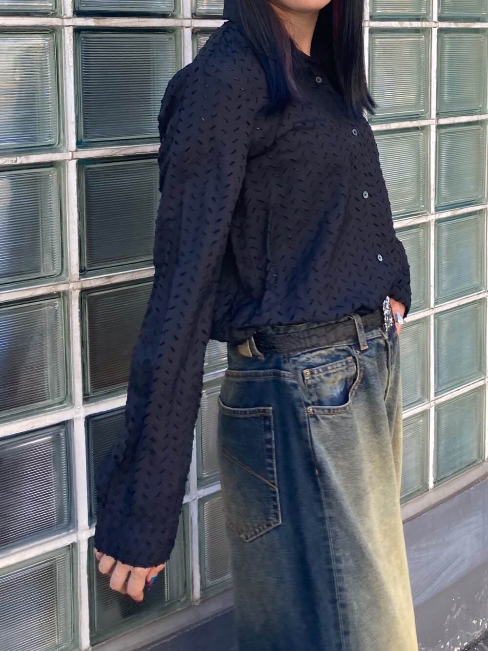 ブルー系のデニムパンツ、ブラック系のベルトを着用したレディースの秋コーディネートの3枚目の写真