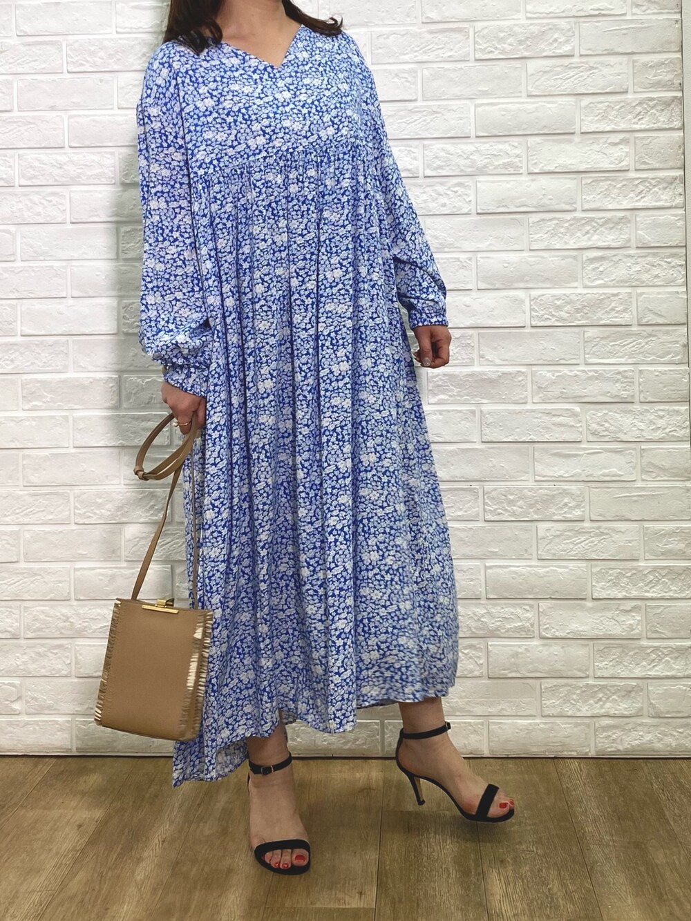 ベージュ系のテーラードジャケット、ブルー系のワンピース、ベージュ系のショルダーバッグを着用したレディースの冬コーディネートの3枚目の写真